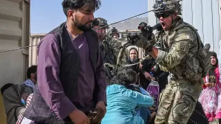 Un soldado estadounidense apunta a un hombre en el aeropuerto de Kabul.