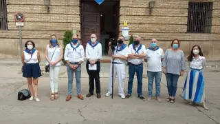 Periodistas con el alcalde, el concejal de fiestas y el pregonero a las puertas del Ayuntamiento con camiseta blanca y pañuelo azul.