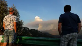 Dos personas observan uno de los pyrocúmulos  generados por el incendio de Sierra Bermeja en Málaga.