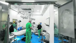Varios profesionales preparan un quirófano de la Clínica del Pilar para una intervención.