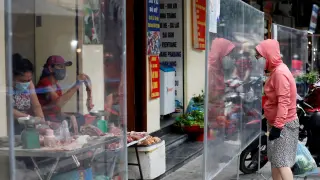 Una mujer, de compras en un mercado de Hanoi en Vietnam