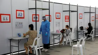 People take their antigen rapid test under supervision in Singapore