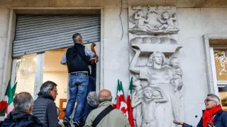 Varias personas arreglando los desperfectos de la sede del sindicato CGIL ITALY CLASHES AFTERMATH