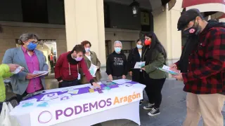 Mesa informativa de Podemos en Huesca para explicar los logros de sus Gobiernos de coalición.
