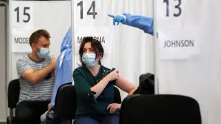 Dos personas recibiendo la vacuna de covid en Bucarest