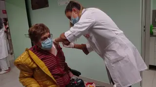 Una aragonesa se vacuna frente a la gripe y con la dosis de refuerzo de la covid, en el centro de salud Almozara.
