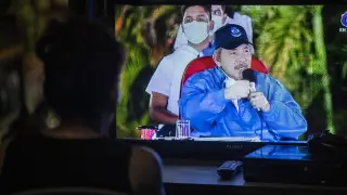 Una mujer sigue el discurso de Ortega en televisión