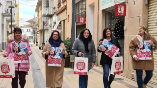 Representantes de la Asociación con bolsas y carteles de la campaña preparada para la Navidad.