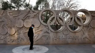 Un hombre junto a un monumento en Pekín que recuerda la celebración en breve de los Juegos Olímpicos.