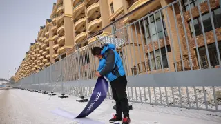 Un trabajador pone una pegatina en Zhangjiakou, una de las sedes de la cita olímpica.