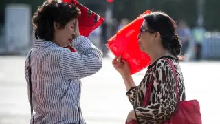 Dos mujeres se protegen del impacto del sol en China.