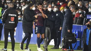 Florian Miguel se retira del campo acompañado por el doctor Sarasa durante el partido con el Girona del domingo.