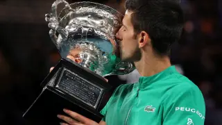 FILE PHOTO: Serbia's Novak Djokovic celebrates with the trophy after winning his ninth Australian Open title