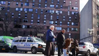 Varias personas rezan delante del edificio siniestrado, en el barrio del Bronx de Nueva York.