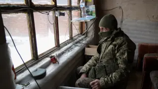 Un soldado ucraniano ve la tele en un móvil mientras en la ciudad de Avdiivka. UKRAINE RUSSIA CRISIS