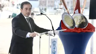 El ministro de Exteriores, Albares, junto a las nuevas mnedas este viernes durante la presentación de su lanzamiento