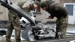 Policias ucranianos inspeccionan los restos de un misil en las calles de Kiev.