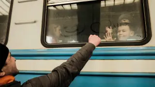 Un refugiado ucraniano se despide de su familia mientras el tren se prepara para partir.