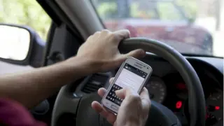 Mirar el móvil mientras conducimos conlleva multa.