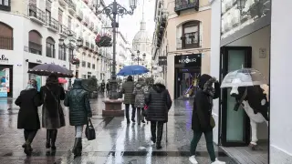 Lluvia en Zaragoza. Gente comprando en la calle Alfonso. Lluvias. gsc