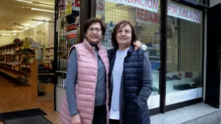 Lucía Garrido, propietaria de Expocalzados Huesca, y Nines Navarro, empleada, a las puertas de la tienda.