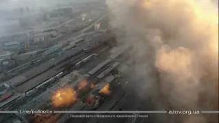 Multiple explosions and rising smoke are seen around an industrial compound, in Mariupol