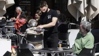 Un camarero atiende una mesa en una de las terrazas de la plaza de España, este jueves en Zaragoza.