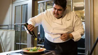El cocinero Hugo López, incorporando un poco de aceite a uno de los platos