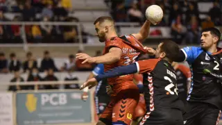 Asier Nieto, del Bada Huesca, sujetado por los jugadores del Sinfín.