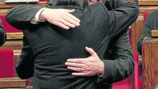 Puigdemont y Mas (de espaldas) se saludan antes del pleno de investidura del primero en enero de 2016.