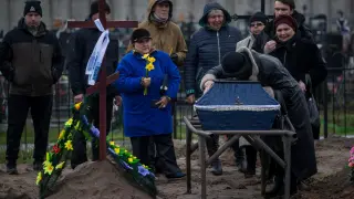 Varios familiares entierran a una persona en el cementerio de Bucha, en Ucrania, este viernes.