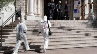 Agentes de la policía científica entran a la iglesia de Niza donde ocurrieron los hechos.