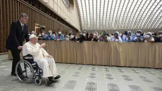 El Papa llega a una audiencia en el Vaticano en silla de ruedas.