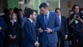 El presidente de la Generalitat, Pere Aragonès y el presidente del Gobierno, Pedro Sánchez, mantienen una conversación en la puerta del hotel W Barcelona.