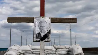 A portrait of Russian President Vladimir Putin in a cross depicting his tomb is seen at a checkpoint outside Dnipro