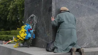 Una señora mayor, ante el memorial al soldado desconocido en Kiev.