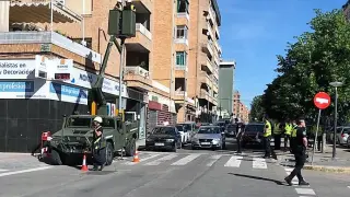 Dos técnicos acceden mediante la cesta elevadora de un vehículo del Ejército a una farola en la esquina de la avenida Menéndez Pidal, junto al recorrido del desfile