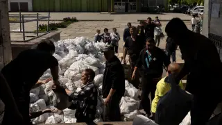 Ucranianos desplazados reciben alimentos en Mahdalynivka.