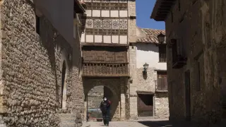 José Miguel Marín, residente de Mirambel y coleccionista de Pío Baroja. Al fondo, el hermoso Portal de las Monjas.