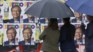 Dos mujeres contemplan carteles electorales del candidato Gustavo Petro en Bogotá.