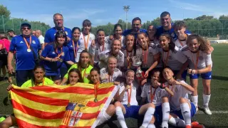 La selección aragonesa sub-15 de fútbol femenino posa con la copa de campeonas.