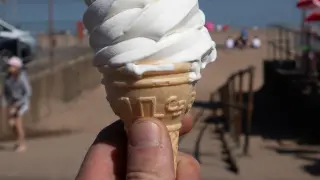 Foto de recurso de un hombre con un helado en la playa