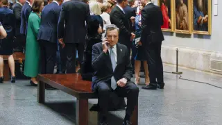 Mario Draghi hablando por teléfono apartado del resto de líderes de la OTAN en el Museo del Prado