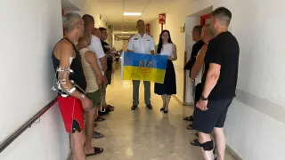 Los ucranianos heridos en el Hospital Militar muestran una bandera de su país cuando ha ido a visitarles la ministtra de Defensa y le agradecieron el apoyo de España.