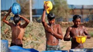 Trabajadores de la construcción se refrescan con agua en la ciudad india de Ahmedabad, en una imagen de archivo.
