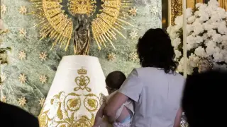Un bebé pasando por el Manto de la Virgen del Pilar.