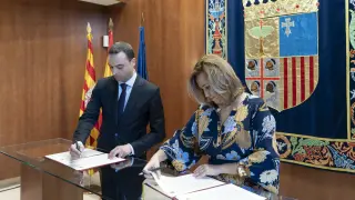 La consejera de Presidencia y Relaciones Institucionales del Gobierno de Aragón, Mayte Pérez (d) y el secretario de Estado de Política Territorial, Alfredo González (i) firman este viernes el convenio del FITE