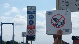 Cartel que avisa de que está prohibido dar de comer a los animales en la desembocadura de la riera de Riudoms en Cambrils. Detrás, el aviso de peligro por ratas.
