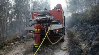Bomberos trabajan en la extinción de un incendio en Boiro