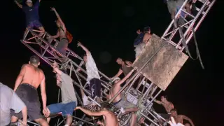Varios de los asistentes, subidos en una de las estructuras del festival que el público destrozó